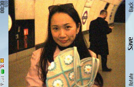 Afra on a London Underground platform, holding a crocheted daisy bag, shot through a retro phone-camera filter